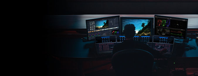 A person working at a desk with several stacked monitors