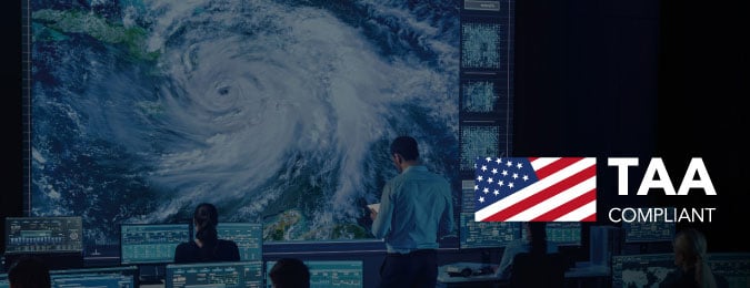 A weather control room overlayed with a US flag image and TAA compliant logo