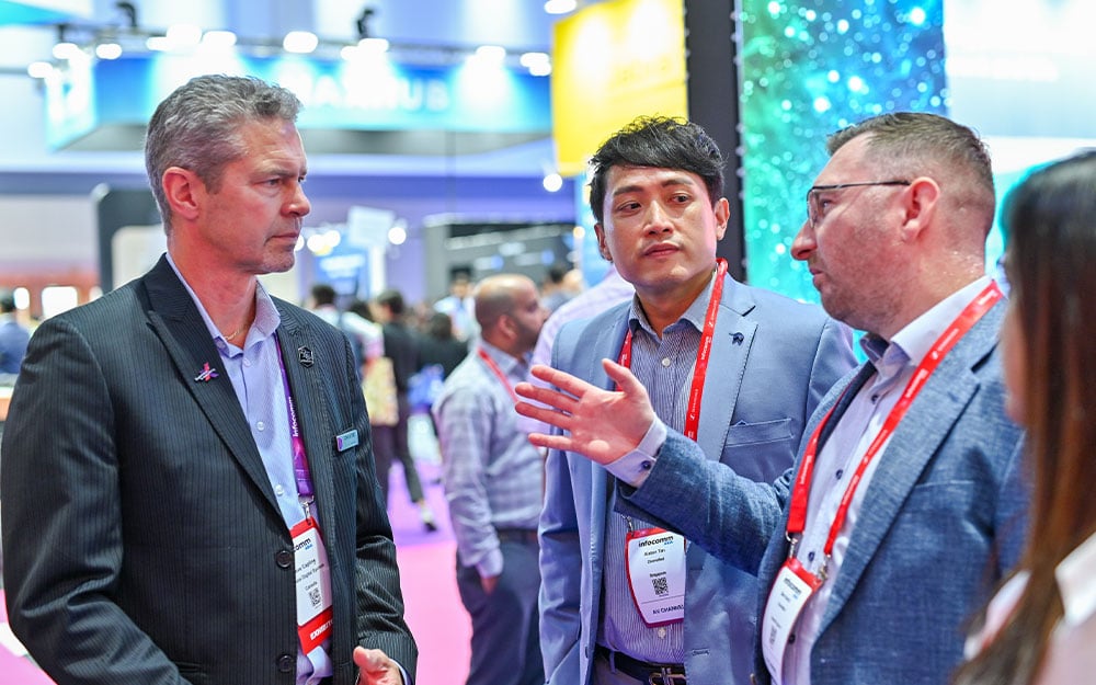 Three people having a conversation at InfoComm Asia