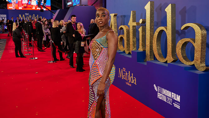 "Miss Honey" (Lashana Lynch) in front of Matilda sign at the BFI London Film Festival