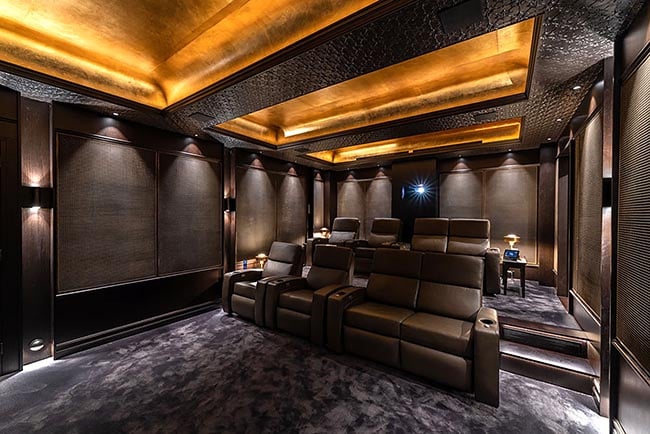 An elegant and luxuriously furnished home cinema adorned with cozy ambient lighting. 