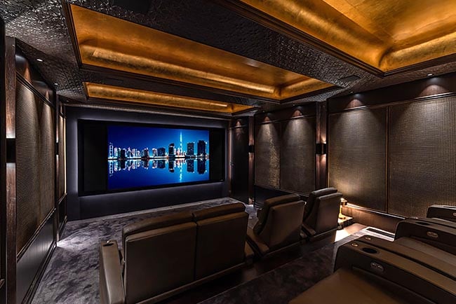 An elegant and luxuriously furnished home cinema fitted with a huge screen.