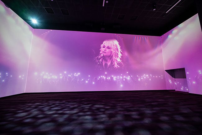 A projected image of Dolly Parton on a large screen.