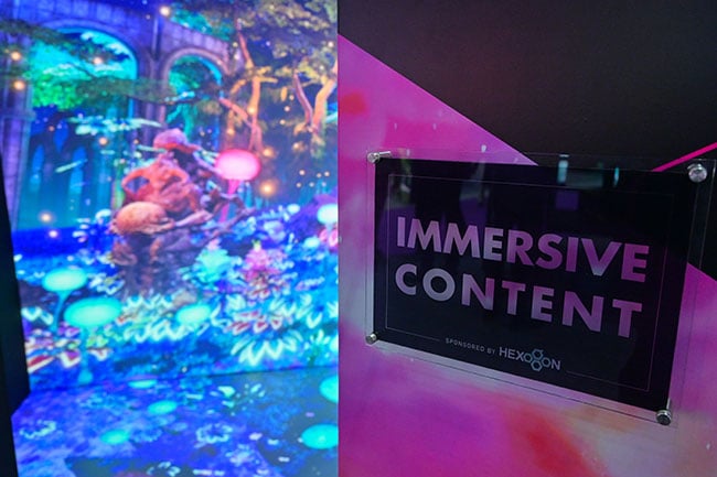 A sign outside of an immersive room reads, “Immersive content sponsored by Hexogon”