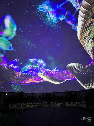 An image of a snake is projected onto a domed ceiling. 