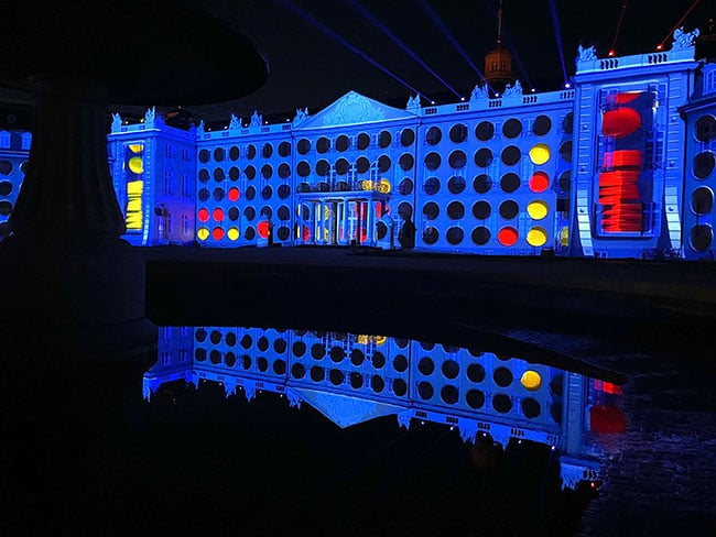 A game of Connect 4 is projection mapped onto the façade of a large building.