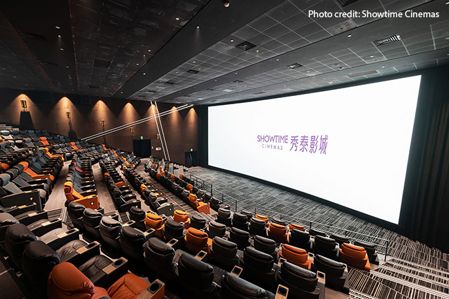 A cinema auditorium with attractive ambient lighting and massive screen.