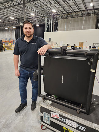 A man poses beside a cinema projector.