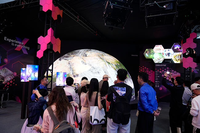 A crowd in front of a projection mapped hemisphere.