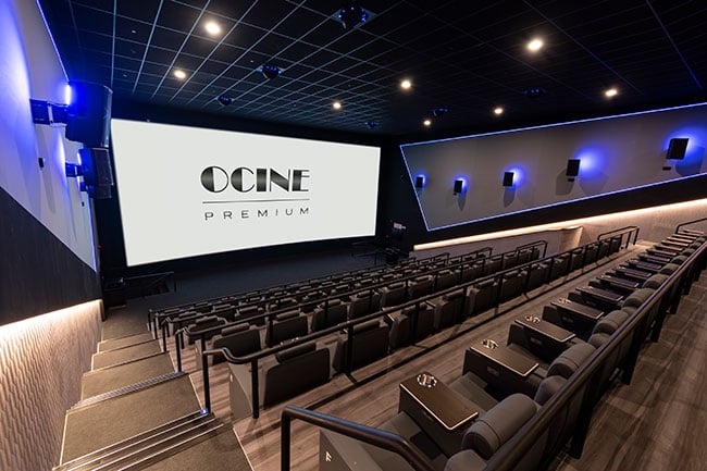 An empty movie theatre with the text “Ocine Premium” projected onto the screen.